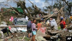 A typhoon survivor stands on rubbish in Tacloban, central Philippines, Dec. 8, 2013.