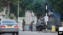 A military tank is seen with armed soldiers on a road leading to President Robert Mugabe's office in Harare, Zimbabwe, Nov. 15, 2017.