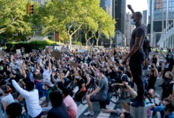 A group of protesters take a knee while marching in lower Manhattan, June 6, 2020, in New York.