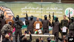 Con tin Israel bị Hamas giam giữ ở Gaza kể từ ngày 7/10/2023, từ trái sang phải, Ohad Ben Ami, Eli Sharabi và Or Levy, được các chiến binh Hamas đưa lên một sân khấu trước khi được trao trả cho Hội Chữ thập đỏ ở Deir al-Balah, Gaza, ngày 8/2/2025. (Ảnh AP/Abdel Kareem Hana)