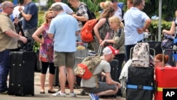 British tourists queue with their luggage to leave by charter flight from the international airport in Mombasa, Kenya Friday, May 16, 2014.