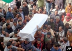 Mourners outside the Benghazi courthouse, seat of the rebel movement, carry the coffin of a victim of a munitions depot blast, March 5, 2011