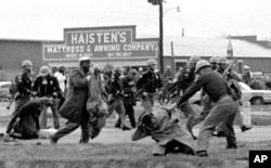 FILE - Alabama state troopers use clubs against voting rights marchers, including John Lewis, shown in foreground, in Selma on March 7, 1965.