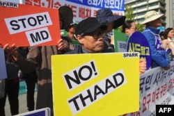 South Korean protesters hold placards during a rally against the deployment of the US Terminal High Altitude Area Defense (THAAD) system near the US embassy in Seoul, April 28, 2017.