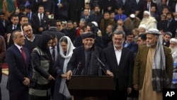 Afghanistan's President Ashraf Ghani, center, speaks to journalists after arriving to register as a candidate for the presidential election at the Independent Elections Commission, in Kabul, Jan. 20, 2019. 