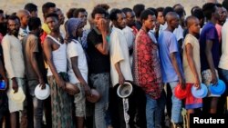 Men who fled fighting in Ethiopia's Tigray region queue for food rations at Um-Rakoba camp, on the Sudan-Ethiopia border, in Al-Qadarif state, Sudan, Nov. 19, 2020.