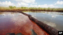 File - In this June 26, 2010 file photo, oil from the Deepwater Horizon oil spill is seen floating on the surface of the water in Bay Jimmy in Plaquemines Parish, La. BP is mounting a new challenge to US government estimates of how much much oil flowed f