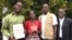 Maseray Kamara, flanked by her fellow burial team members in Freetown, holds the the Bond International Humanitarian Award, given to burial teams from across Sierra Leone for their contributions to stopping the spread of the Ebola virus, June 5, 2015.