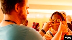 Opthamalogist Kristin Coffey (L) tests Horjera Khatum’s vision during an eyecare visit at the Kutupalong Government Primary School, Bangladesh, Feb. 13, 2020. (Hai Do/VOA) 