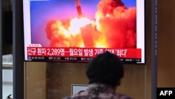 People watch a television news broadcast showing file footage of a North Korean missile test, at a railway station in Seoul on Sept. 28, 2021, after North Korea fired an "unidentified projectile" into the sea off its east coast, according to the South's military.