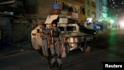 Afghan policemen stand guard near the site of an attack on a shrine in Kabul, Afghanistan October 11, 2016. 