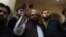 FILE - Hafiz Saeed, head of the Pakistan's Jamaat-ud-Dawa group, waves to supporters in Lahore, Pakistan, Nov. 24, 2017. Pakistan has amended its anti-terrorism law that authorizes the government to blacklist charities linked Saeed, who has been wanted since 2012 for his role in planning the 2008 Mumbai terror attack. 
