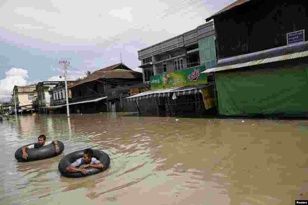 Men wade along a flooded street in Kalay township, Sagaing region, Aug. 2, 2015.