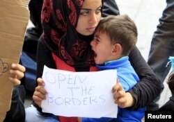 A migrant holds a sign in front of Keleti railway station in Budapest, Hungary, Sept. 4, 2015.