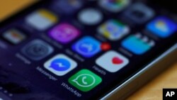 FILE - A WhatsApp icon (bottom, center) is seen on an iPhone in this March 27, 2017, illustration photo.