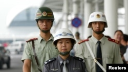 FILE - Chinese police patrol the Baiyun International Airport in Guangzhou, Aug. 5, 2004. 
