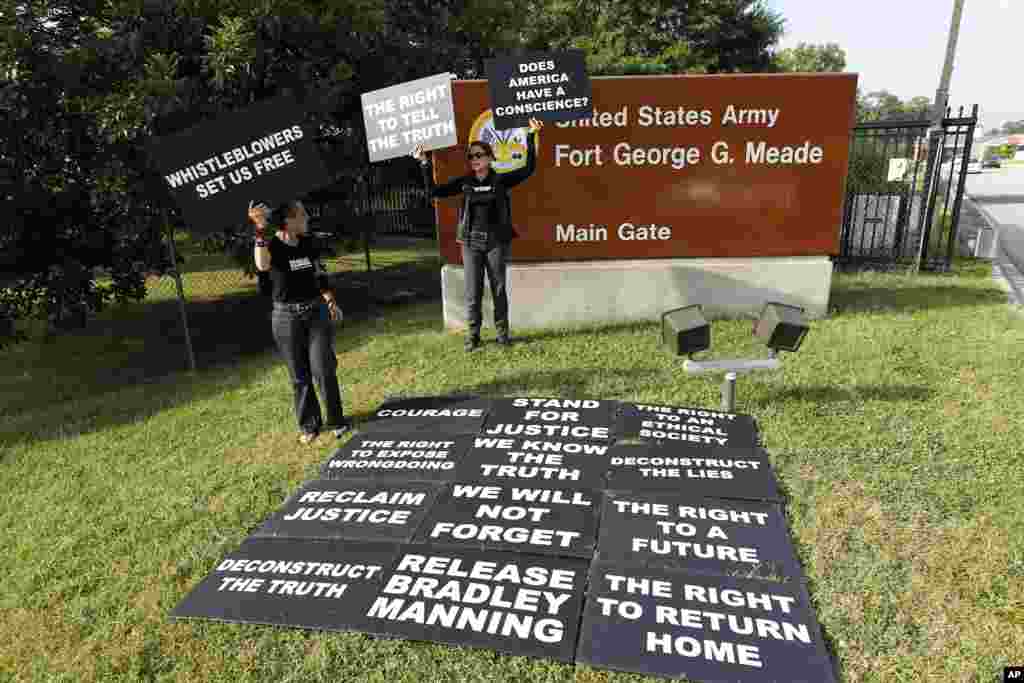 Supporters of Army Pfc. Bradley Manning hold up signs as they protest outside of the gates at Fort Meade, Maryland, August 21, 2013.