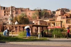 FILE - Visitors walk past the old city district in Kashgar, western China's Xinjiang region, Aug. 31, 2018. Police confirmed that Lu Guang, a prominent Chinese photographer who went missing more than a month ago was arrested, his wife said.