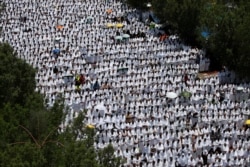 FILE - Muslim pilgrims pray outside Namira Mosque on the plains of Arafat during the annual hajj pilgrimage, outside the holy city of Mecca, Saudi Arabia, Aug. 10, 2019.