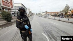 FILE - A security man stands in an empty street in Sulaimaniya, in Iraqi Kurdistan, March 14. 2020. 