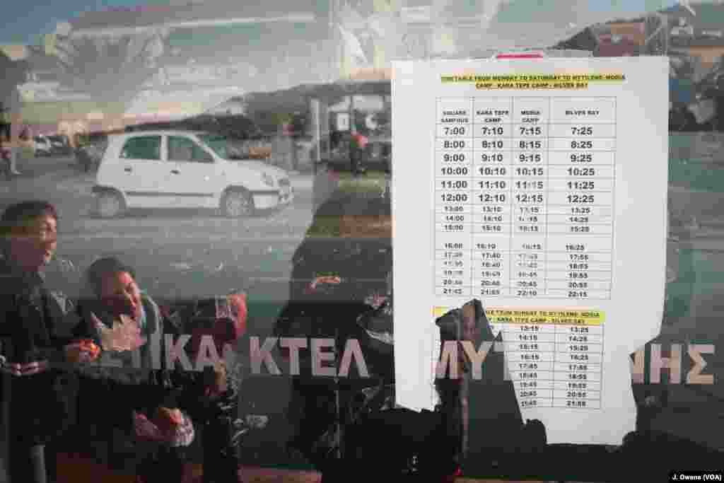 Refugees wait for a bus in Mytilene, the capital city of Lesvos. 