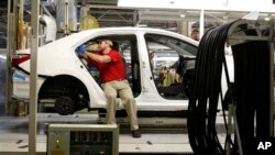 Technicians work on a Toyota Corolla assembly line, Blue Springs, Mississippi, Feb. 12, 2015.