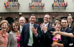David Turley and his husband Peter Thiede display their wedding bands while posing for photos with friends and family, June 28, 2015 in front of New York's Stonewall Inn. New York Gov. Andrew Cuomo earlier wed the New York City couple.