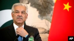 FILE - Pakistan's Foreign Minister Khawaja Muhammad Asif adjusts his necktie during a joint press conference at the Diaoyutai State Guesthouse in Beijing, Sept. 8, 2017.