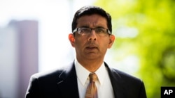 Dinesh D'Souza exits the Manhattan Federal Courthouse after pleading guilty in New York, May 20, 2014. D'Souza pleaded guilty to one criminal count of making illegal contributions in the names of others.