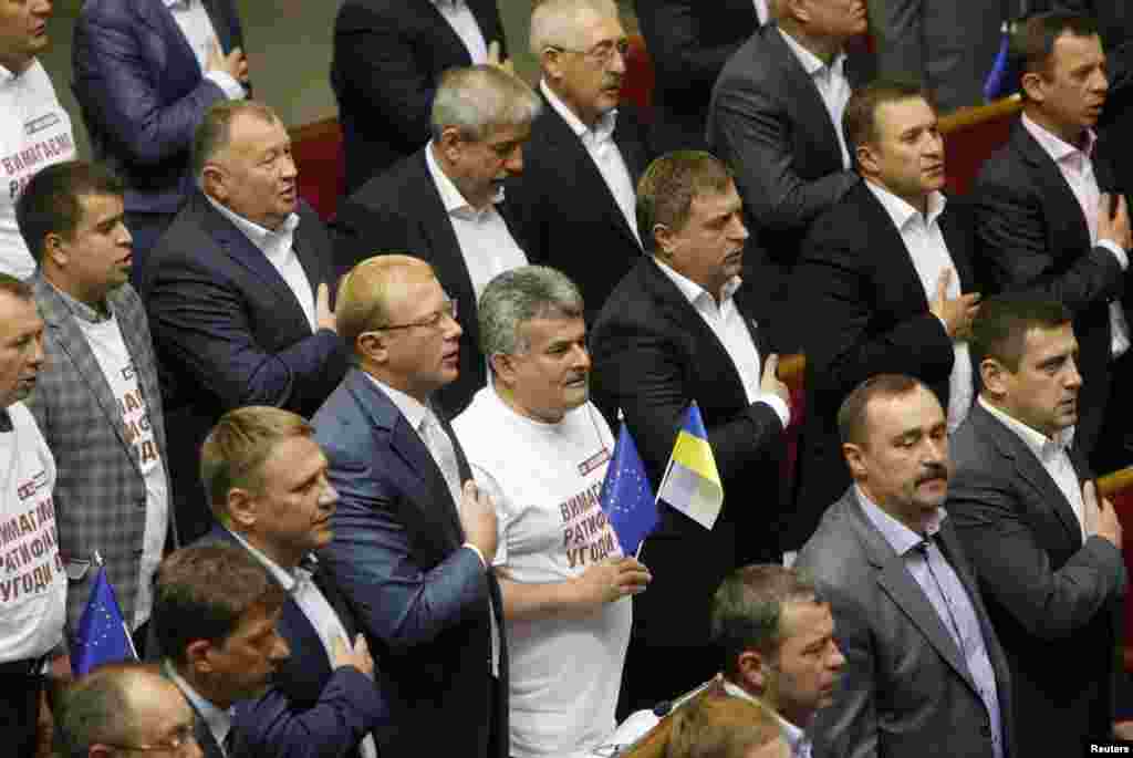 Ukrainian lawmakers sing the national anthem after ratifying a landmark association agreement with the European Union during a parliament session in Kyiv Sept. 16, 2014.