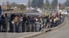 FILE - South African commuters line up at a bus stop in Soweto, May 17, 2010, during a strike by rail workers. Currently, a nationwide bus strike, in its fourth week, is causing similar lines to form for minibus taxis.
