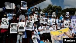 Nicaraguan expats living in Costa Rica hold pictures of people killed in riots or imprisoned as they take part in the "Caravan for Liberty and Justice" to protest against the government of Nicaraguan President Daniel Ortega, in La Cruz, Costa Rica, on the