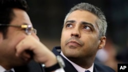 Canadian Al Jazeera English journalist Mohammed Fahmy, listens to his lawyer, Khaled Abou Bakr during his retrial in a courtroom, of Tora prison, in Cairo, Egypt, June 1, 2015.
