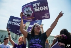 FILE - Renee Bracey Sherman of Chicago, Illinois, celebrates at the Supreme Court in Washington, June 27, 2016, after the court struck down Texas' widely replicated regulation of abortion clinics.