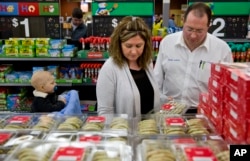 Chesla and Steven Whitt shop for holiday cookies with their nine-month old son, Tommy Joe, in Morehead, Ky., Dec. 14, 2017.