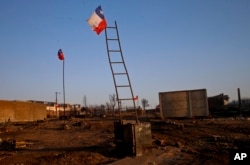 National flags fly over the scorched landscape of Chile's Santa Olga community, Jan. 31, 2017.