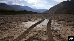 Las marcas de las ruedas de un tractor en el lecho de un río de La Paz, cubierto por el lodo debido a las persistentes lluvias, en El Peñol, Bolivia, el viernes 23 de febrero de 2024. 