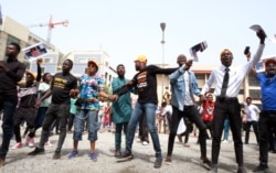 FILE - Supporters of the organizer of "Revolution Now," Omoyele Sowore, hold placards during a protest outside the Federal High Court in Abuja, Nigeria, Feb. 12, 2020.