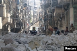FILE - People inspect a site hit by an airstrike in the rebel held area of Aleppo's al-Sukari district, Syria, May 30, 2016.