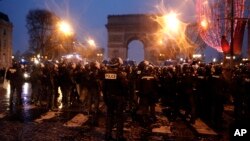 Police secure the Champs-Elysees, Dec. 15, 2018, in Paris. Protests against France's high cost of living — sapped by bad weather and recent concessions by French President Emmanuel Macron — were significantly smaller Saturday than at previous rallies.