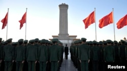 FILE - Paramilitary policemen stand in formation as they pay tribute to the Monument to the People's Heroes on Tiananmen Square in Beijing, November 2013.