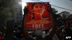 រូប​ឯកសារ៖ នៅ​ក្នុង​រូបថត​​ថត​កាល​ពី​ថ្ងៃ​ទី​១៥ ខែ​កុម្ភៈ​ឆ្នាំ​២០២១ នេះ បាតុករ​កាន់​បដា​រូប​លោកស្រី Aung San Suu Kyi ដើម្បី​ប្រឆាំង​នឹង​រដ្ឋប្រហារ​យោធា នៅ​ក្នុង​ទី​ក្រុង​រ៉ង់ហ្គូន​ប្រទេស​មីយ៉ាន់ម៉ា។ 