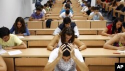 Students take a university entrance examination at a lecture hall in the Andalusian capital of Seville, southern Spain. Researchers created a technique involving having test-takers write down their fears – in turn dramatically improving their test scores 