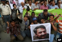 FILE - Pakistani journalists protest to condemn an attack on their colleague, Ahmed Noorani, in photo, in Karachi, Pakistan, Oct. 30, 2017.