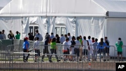 Niños inmigrantes centroamericanos hacen fila para entrar a una casa de campaña en el centro de detención temporal de Homested, Florida. [Foto: Archivo]