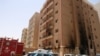 Kuwaiti firefighters and security forces gather outside a building which was ingulfed by fire, in Kuwait City, on June 12, 2024.