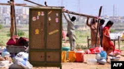 People displaced by the flooding in Pakistan prepare to set a tent at a makeshift camp on the outskirts of Hyderabad, Sindh province, Sept. 2, 2022.