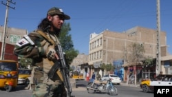A Taliban fighter stands guard on a road after a blast during Friday prayers at Guzargah mosque, in Herat, Sept. 2, 2022.