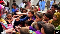 Children line up for handouts after heavy rains in Jaffarabad, a district of Pakistan's southwestern Baluchistan province, Sep. 3, 2022. 