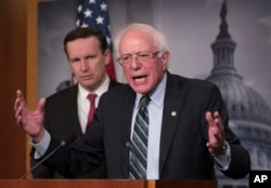 FILE - Sen. Bernie Sanders, I-Vt., joined at left by Sen. Chris Murphy, D-Conn., holds a news conference after the Senate passed a resolution he introduced that would pull assistance from the Saudi-led war in Yemen.